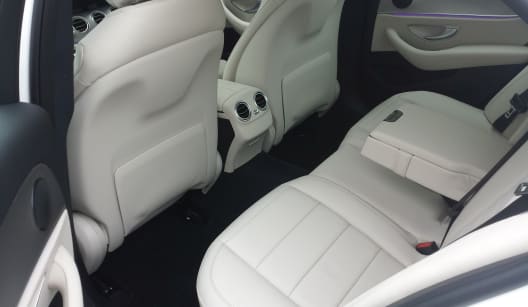 The left hand side passenger interior of a white two seater Mercedes E Class luxury saloon car