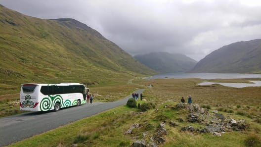 A mid sized luxury coach in the mountains of Ireland with guests