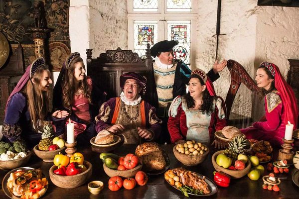 Guests in medieval costume seated at the banquet table inside Bunratty Castle
