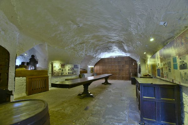 The Cellar Room inside Bunratty Castle, a low-ceilinged space with stone walls and a dirt floor