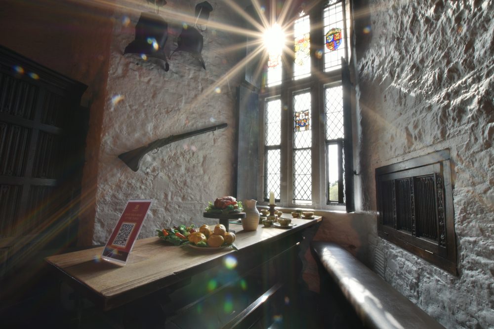 Sunlight through a stained-glass window falling across a table laid for the banquet inside Bunratty Castle