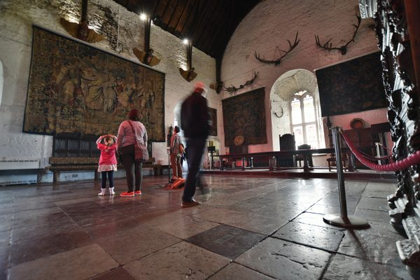 The Great Hall inside Bunratty Castle, with its tapestries, stone walls and arched windows