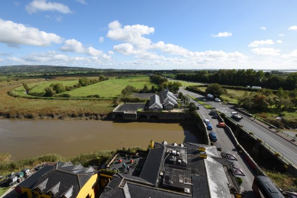 Looking down from the top of Bunratty Castle over the river, its bridge and the road below