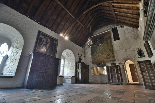 The Great Hall at Bunratty Castle, with its high timber roof, a large tapestry and deep arched windows