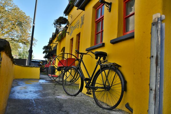 A yellow-walled lane in Bunratty village with a bicycle leaning against the wall
