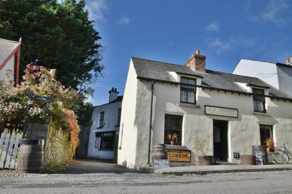 A shopfront on the village street at Bunratty Folk Park, with barrels and hanging baskets outside