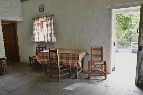 The kitchen and dining room of a farmhouse at Bunratty Folk Park, with its table set below the window