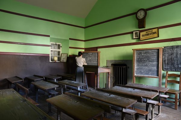 The schoolroom at Bunratty Folk Park, with the schoolmistress at work among the wooden desks and blackboards