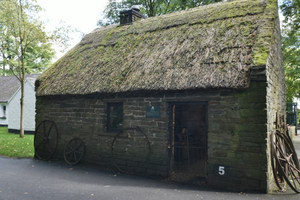 A low stone cottage with a thatched roof at Bunratty Folk Park