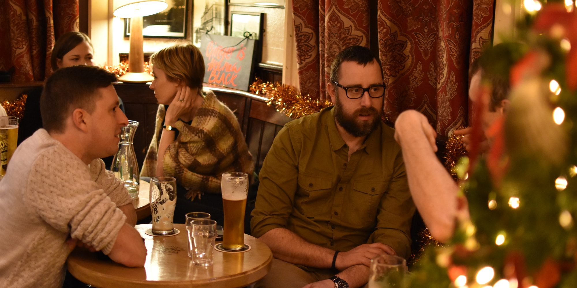 Guests chatting over drinks in a traditional Irish pub