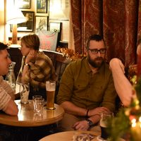 Guests chatting over drinks in a traditional Irish pub