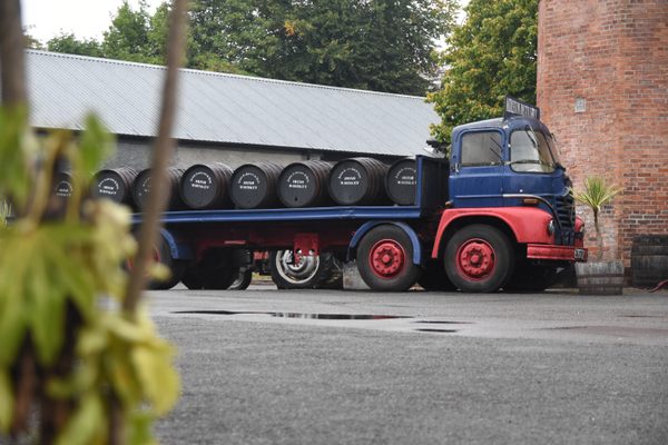 A vintage truck loaded with whiskey barrels