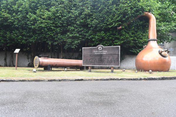 The Irish Whiskey Academy sign beside a copper still